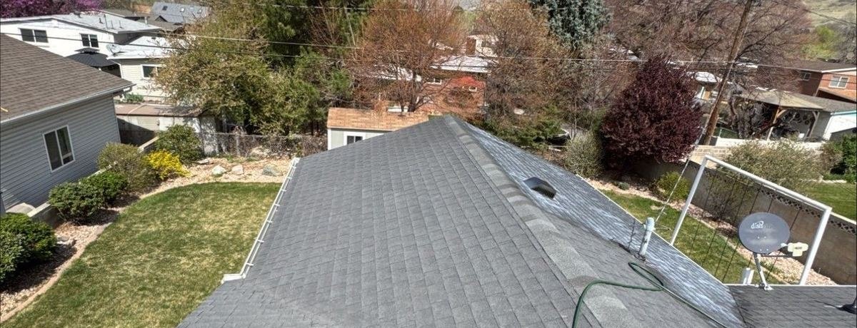 Faded grey asphalt shingle roof before restoration treatment on a Utah home