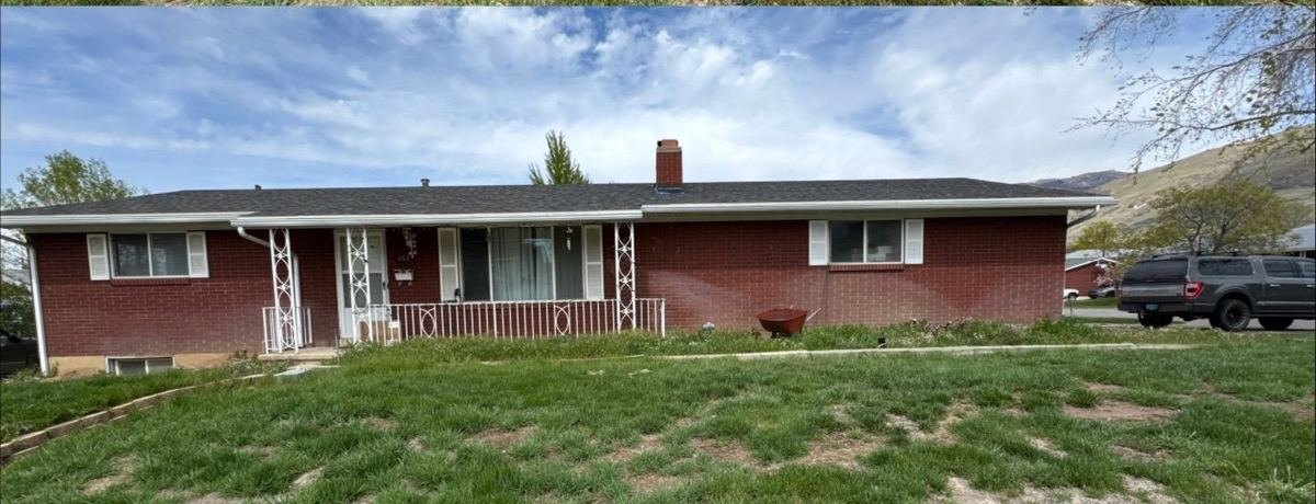 The same Utah brick ranch home after roof rejuvenation, with even restored shingle color