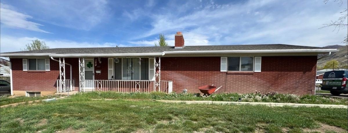 Utah brick ranch home with a faded, weathered asphalt shingle roof before restoration