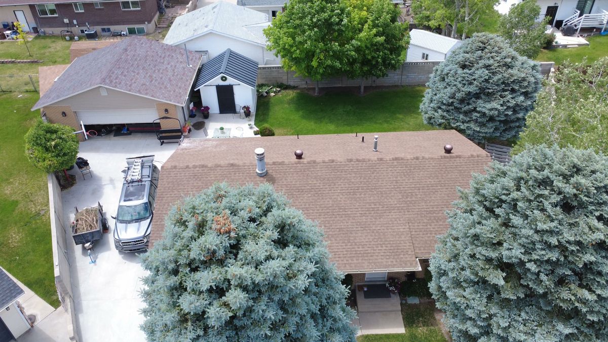 Aerial view of a Utah home being measured and photographed for a roof restoration quote
