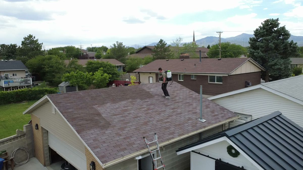 Revive Your Roof technician with the treatment underway, on a Wasatch Front home in Utah