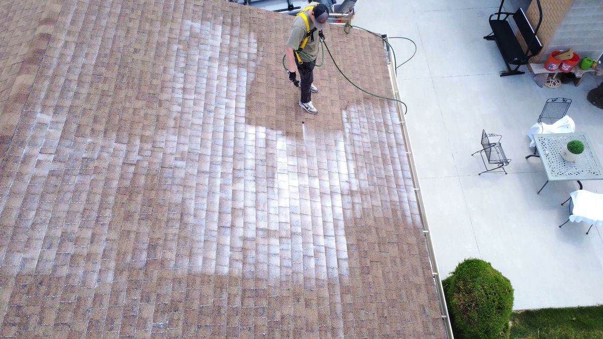 Drone view of a weathered asphalt shingle roof being treated in Utah