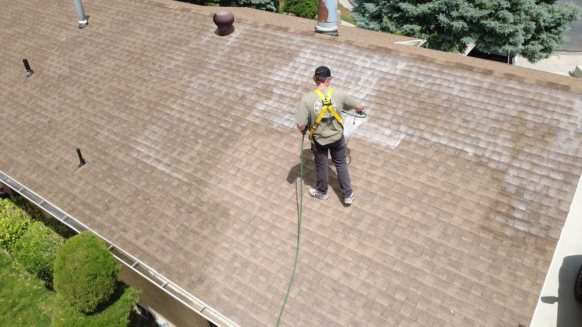 Close drone view of restoration treatment being applied to asphalt shingles