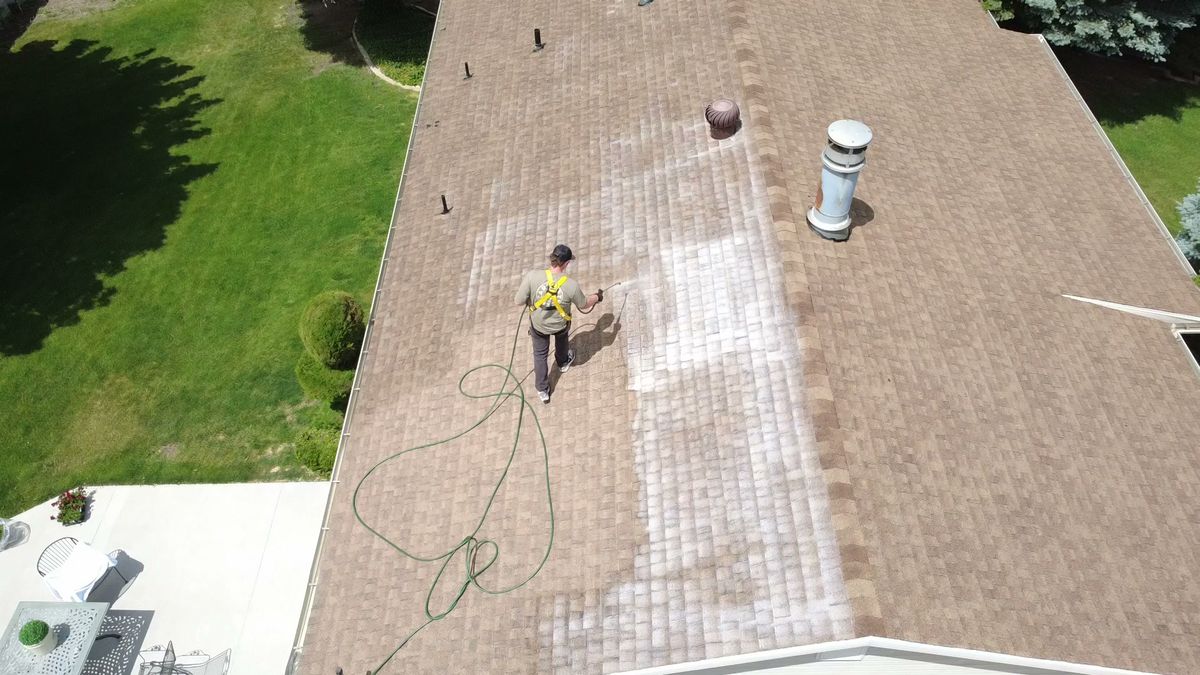 Revive Your Roof technician treating a roof slope, seen from directly overhead, on a Wasatch Front home in Utah