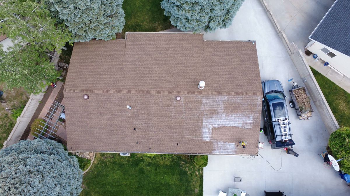 Overhead drone view of a full asphalt shingle roof being inspected in Utah, every slope visible